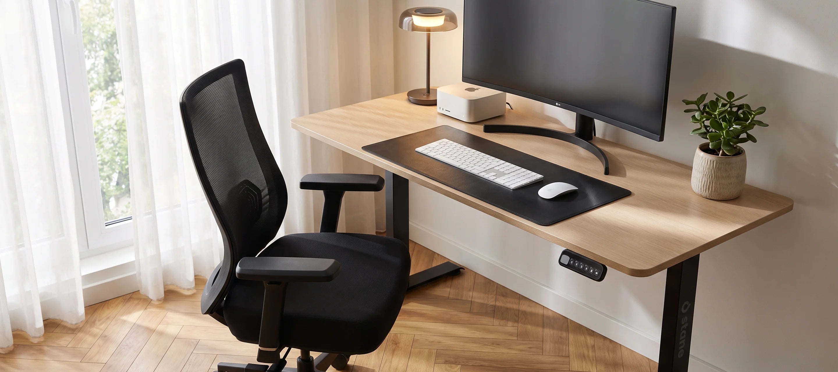 De Stane Pro aan een licht eiken bureau in een compacte thuiswerkkamer met zacht ochtendlicht.