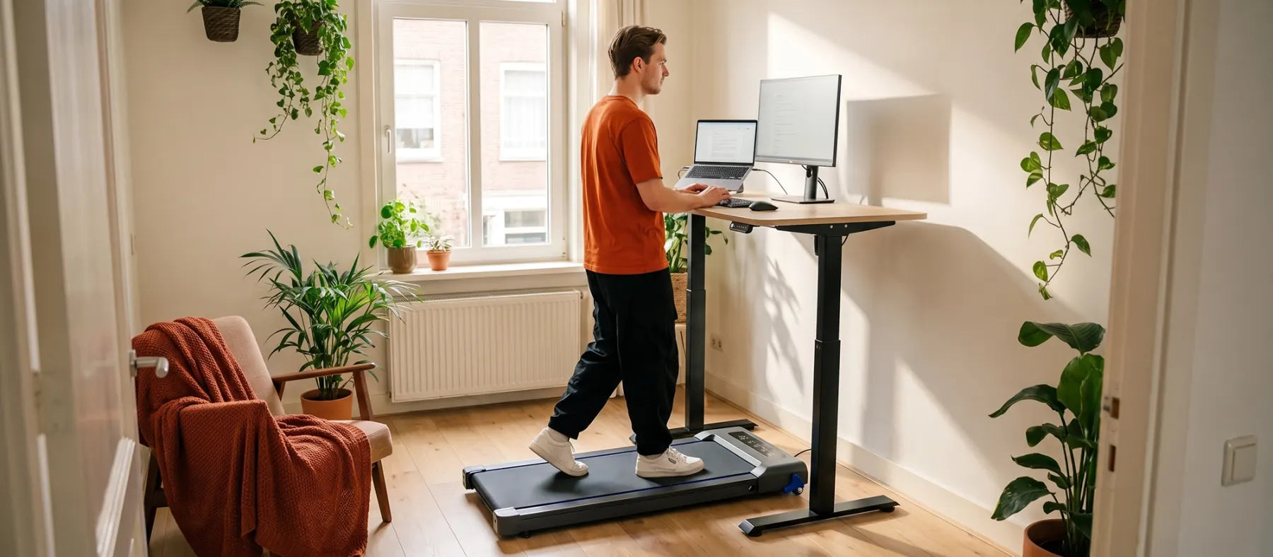 Thuiswerker wandelt rustig op de Stane loopband aan een licht zit-sta bureau